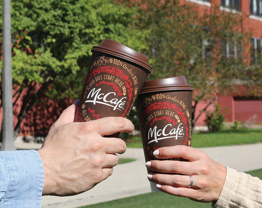 two people clinking McDonald's coffee cups