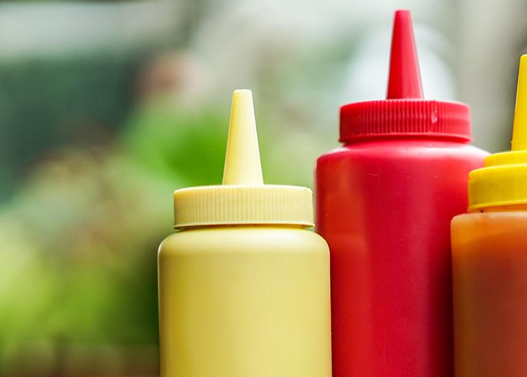 close-up of ketchup, mustard and hot sauce squeeze bottles