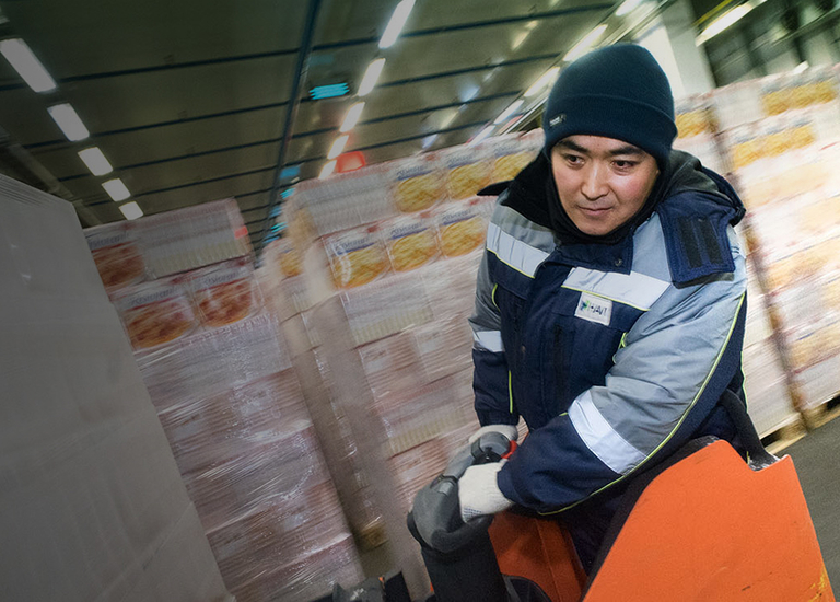 Distribution roles - Asian DC worker driving pallet into place